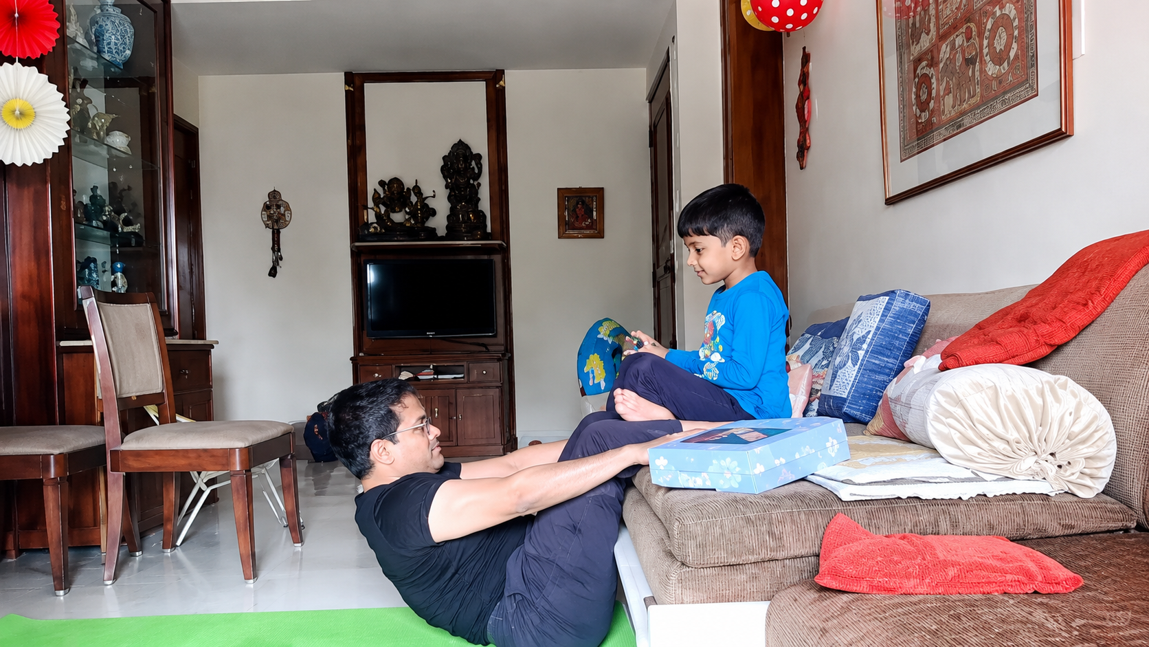Partner yoga pose practiced together on the living room sofa